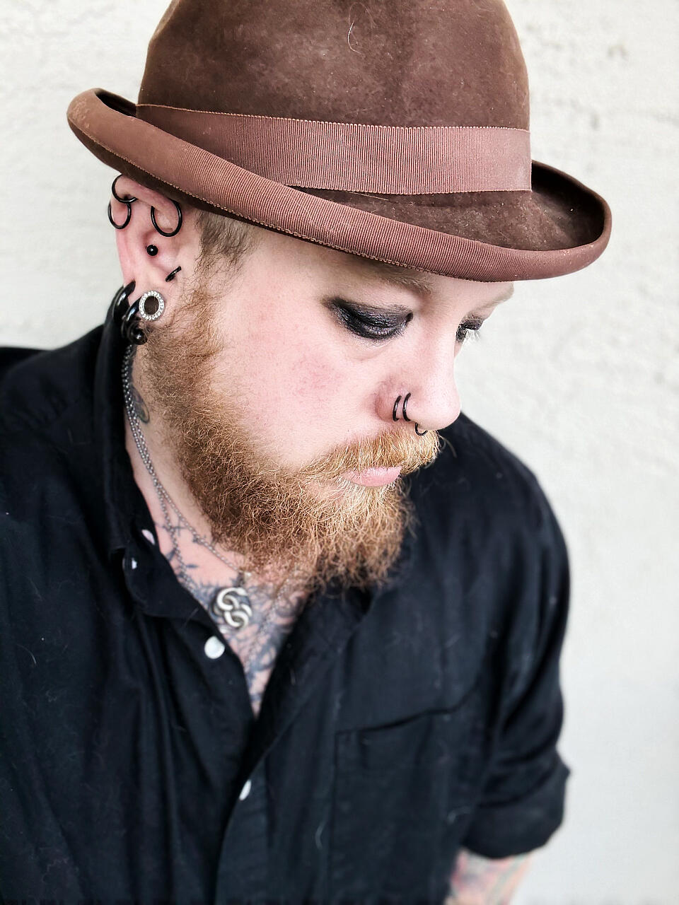 A photo of Lee wearing a black tank top, with green and gold cyberfalls in his hair, and circuit diagrams drawn on his face